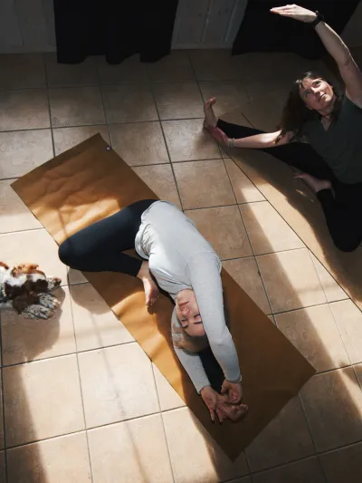 Yoga på et badegulv med en hund som ser på.