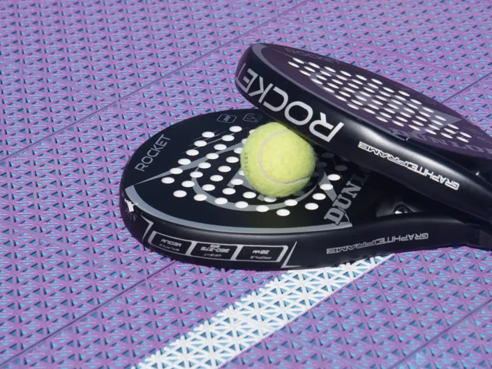 Padelutstyr med lilla i bakgrunnen.