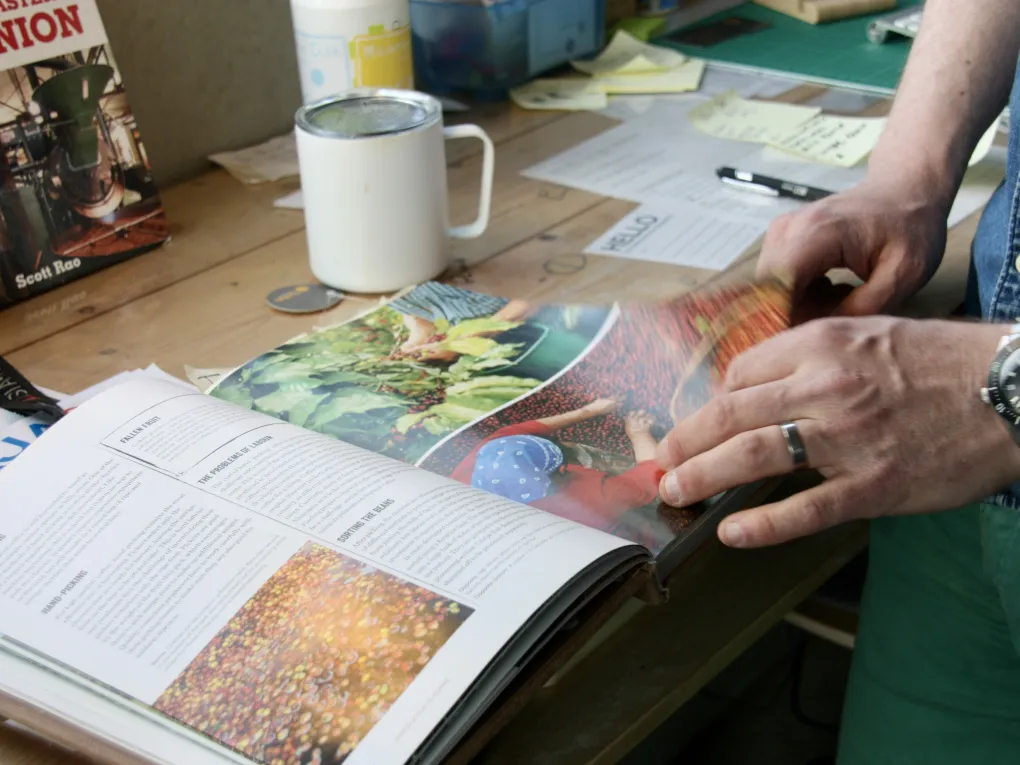 A man flipping through a book about coffee.