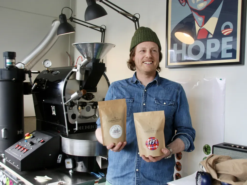 Mann på en kafé, med to kaffeposer.