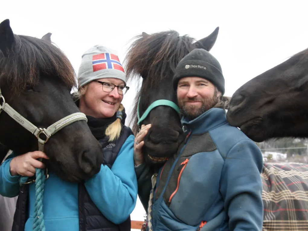 To mennesker og tre hester som smiler