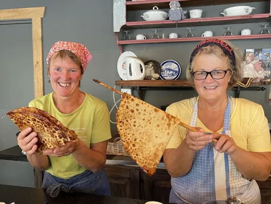 To damer som lager mat på en kafe