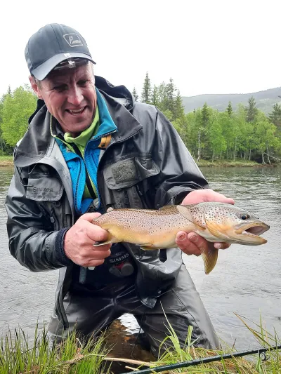 Mann i vannet som nettopp har fanget en fisk