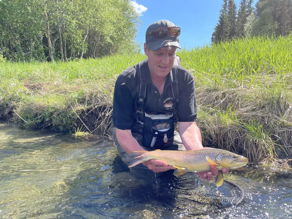 Mann i vannet som nettopp har fanget en fisk