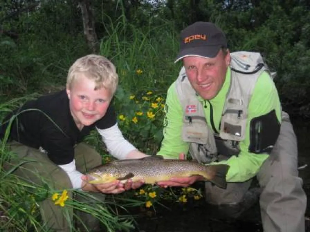 Far og sønn som har fått fisk