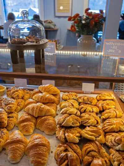 Bilde av ulike bakevarer i disk med mennesker i bakgrunnen