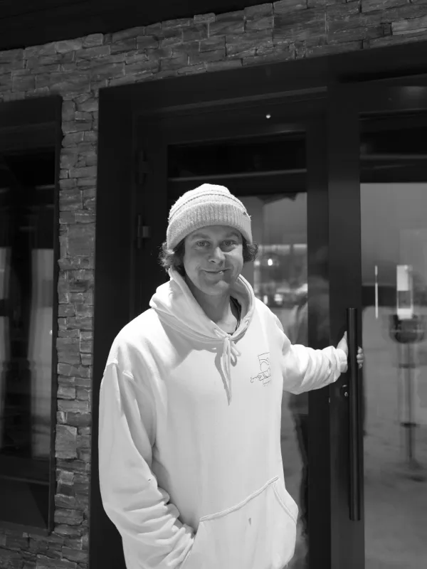 Nærbilde av en mann stående utenfor inngangen til restauranten