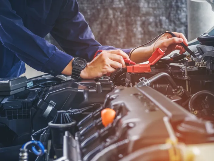 En som fikser noe på en bil.