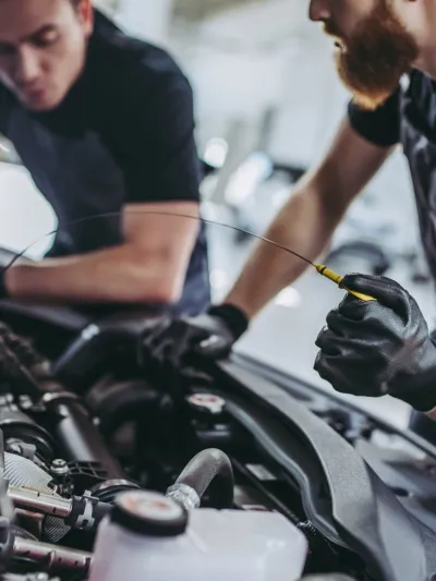 To menn som fikser noe på en bil.