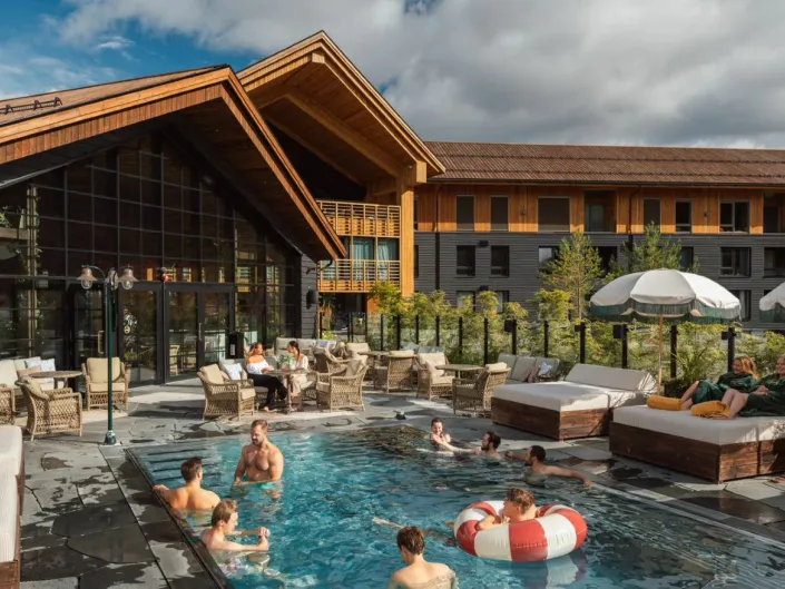 Pool club med folk som bader foran hotell