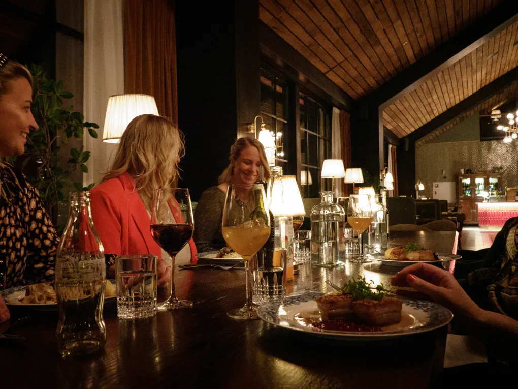 Jenter som sitter på middag og koser seg