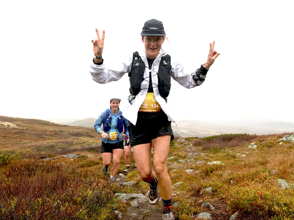 Glad jente som løper i fjellet