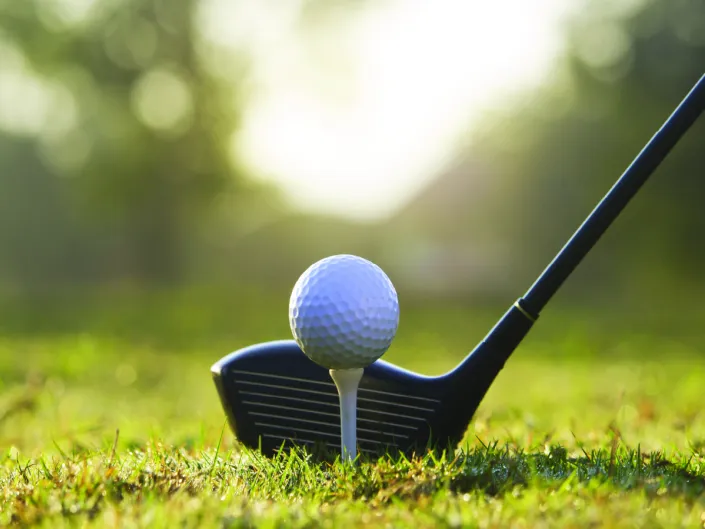 Nærbilde av en golfball og en golfkølle