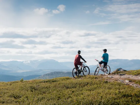 Stisykling på Golsfjellet Visit Gol Paul A Lockhart, to personer som sitter på syklene sine og ser utover fjellet.