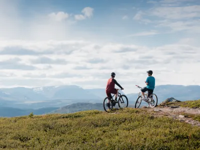 Stisykling på Golsfjellet Visit Gol Paul A Lockhart, to personer som sitter på syklene sine og ser utover fjellet.