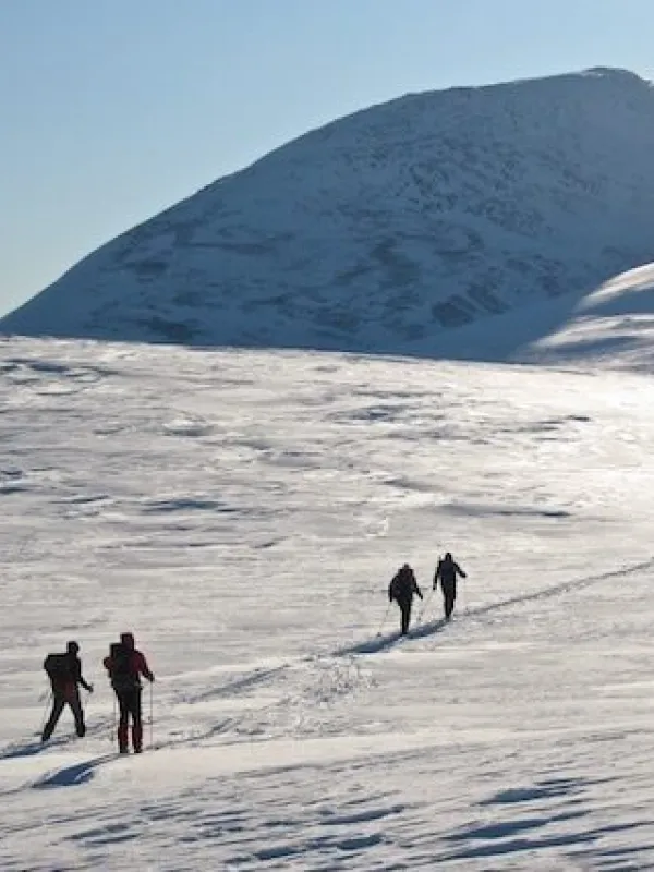 Topptur bilde fra avstand, med mennesker som går oppover i fjellet.