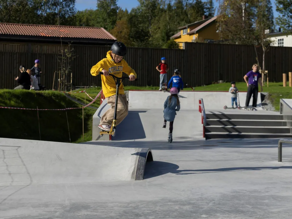 Gutter og jenter som bruker parken, til å skate eller sparkesykle.
