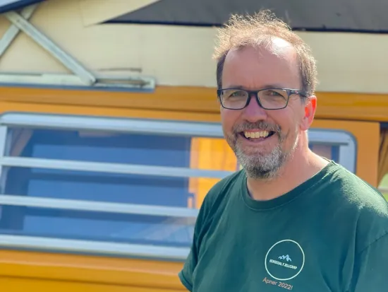 Mann i grønn t-skjorte som smiler.