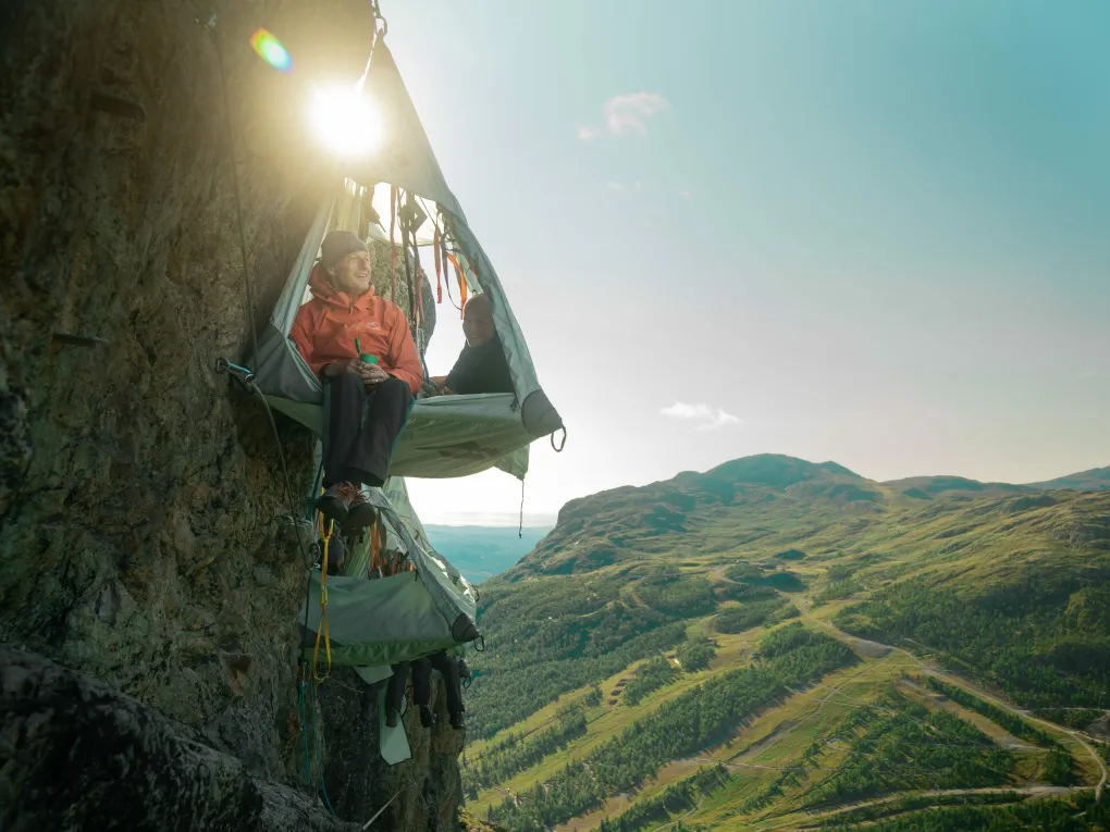 Mann i telt i soloppgang som har sovet i skysleep