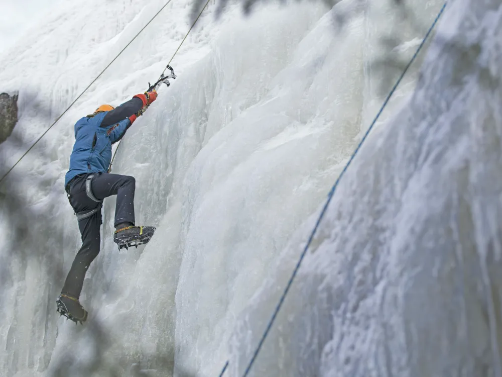 En mann i isveggen som klatrer med isøks