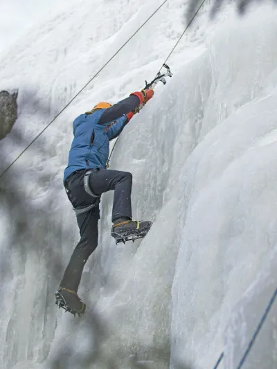 En mann i isveggen som klatrer med isøks