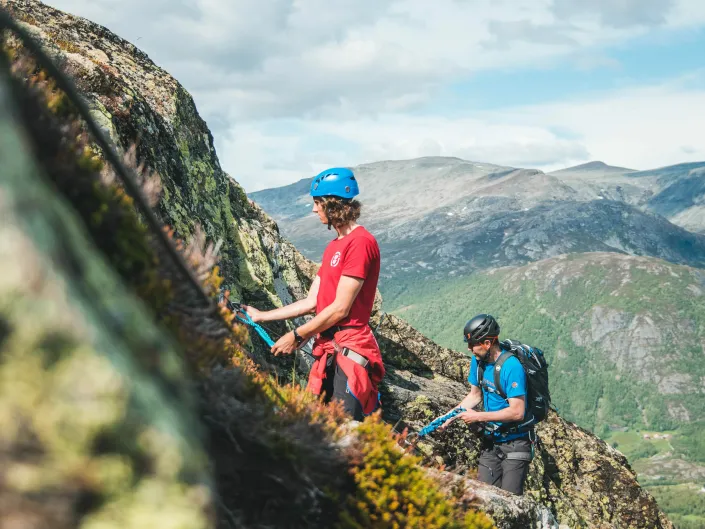 To personer som går oppover fjellet på via ferratta
