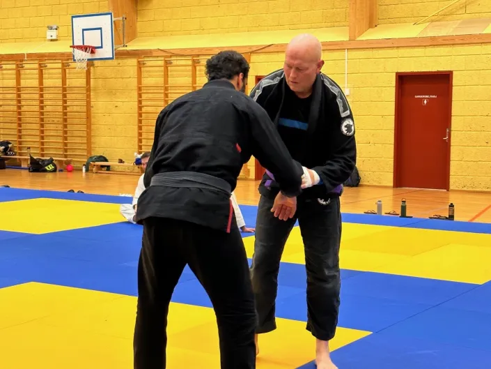 To menn ikledd svart drakt, gjør seg klare til å bryte med hverandre.