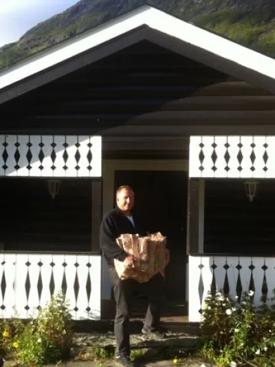 Mann som bærer ved inn i en hytte