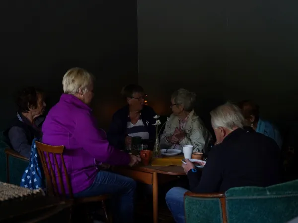 En gjeng som hygger seg rundt et bord på flattbrødbakeriet.