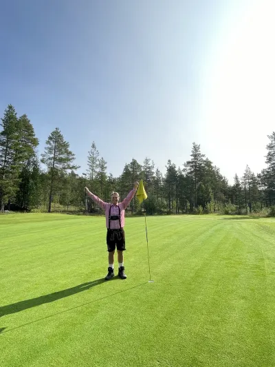 Oktoberfest på golf-coursen, en mann ikledd oktober drakt med henda i været.