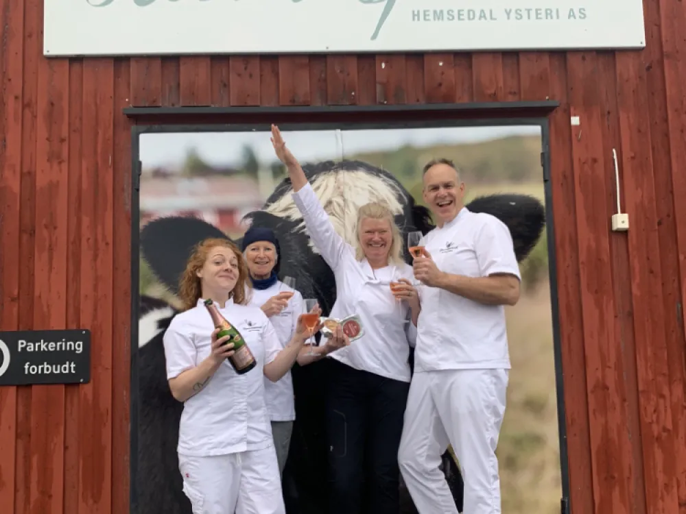 Mennesker som smiler til kamera, foran inngangen på himmelspannet