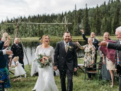 To mennesker som har giftet seg smiler mens de går mot kamera