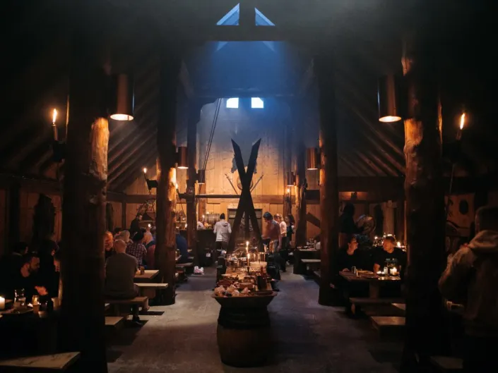 Ett kveldsbilde av fest på låve med dekket langbord