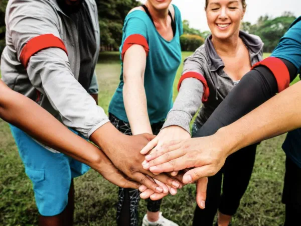 Fem mennesker som holder hendene frem