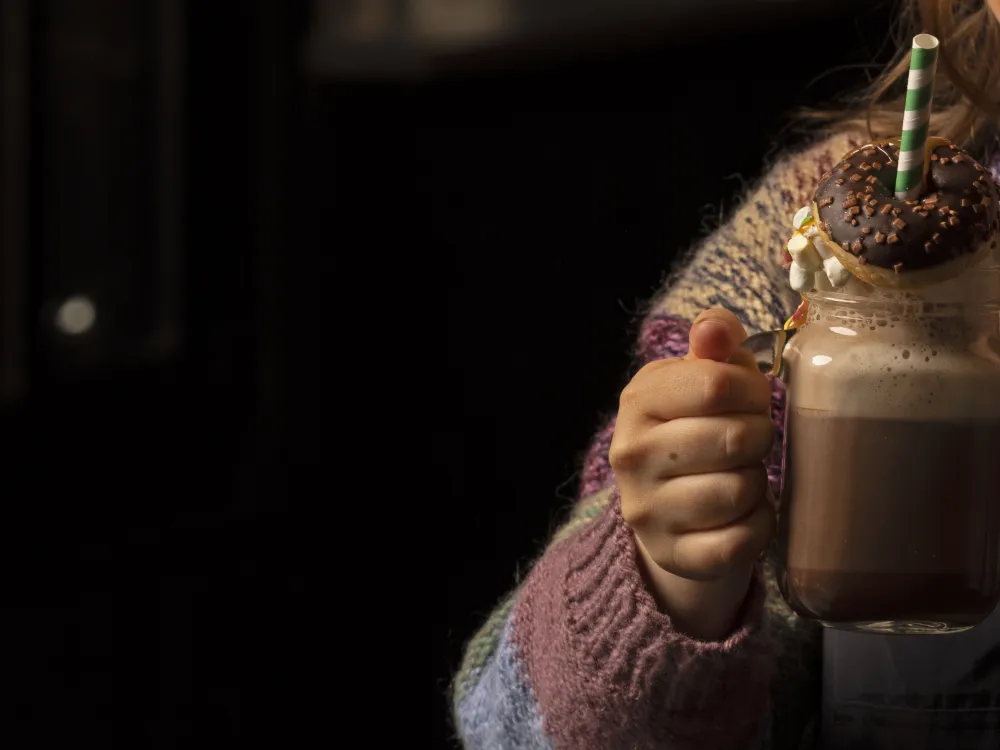 Jente holder en kakao med krem