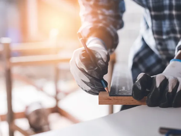 Mann som til ulike mål på en planke med tre