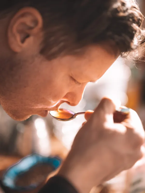 Mann som smaker på kaffe