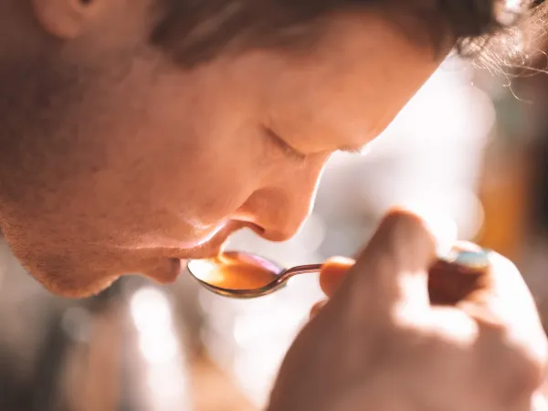 Mann som smaker på kaffe