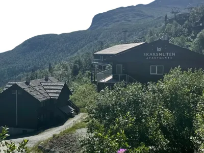 Leiligheter i svart med skriften skarsnuten apartments på sommerstid.