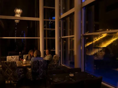 Tre damer som hygger seg på skarsnuten, i bakgrunnen er det skibakken på kveldstid.