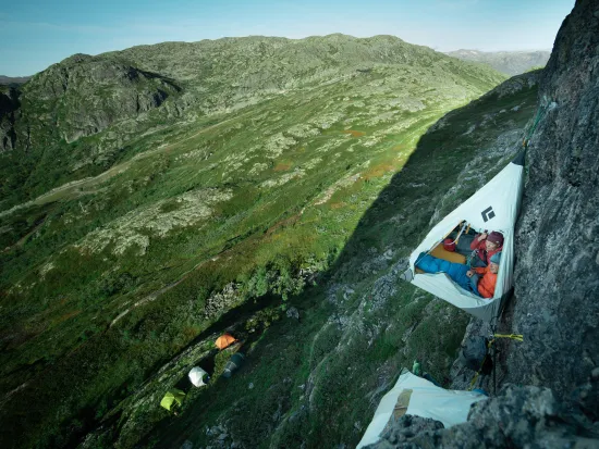 skysleeping telt i fjellveggen, med mennesker i.