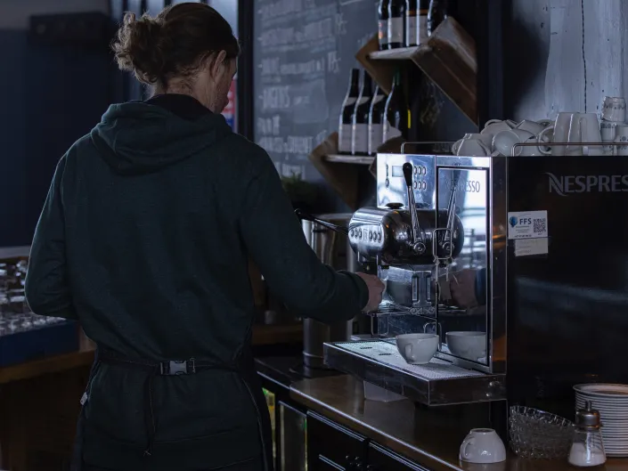 Mann som lager kaffe på kafeen i solheisen Hemsedal