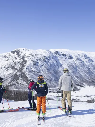 Familie som er på ski i solheisen i Hemsedal