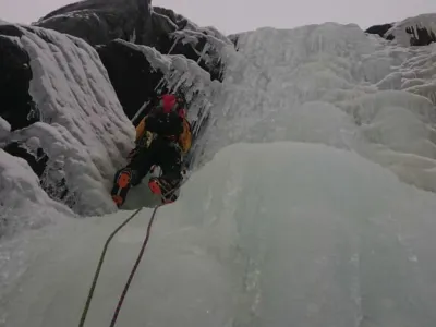 Nærbilde av en som isklatrer i en foss.