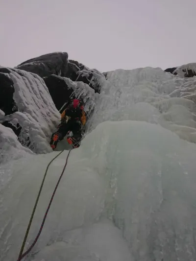 Nærbilde av en som isklatrer i en foss.