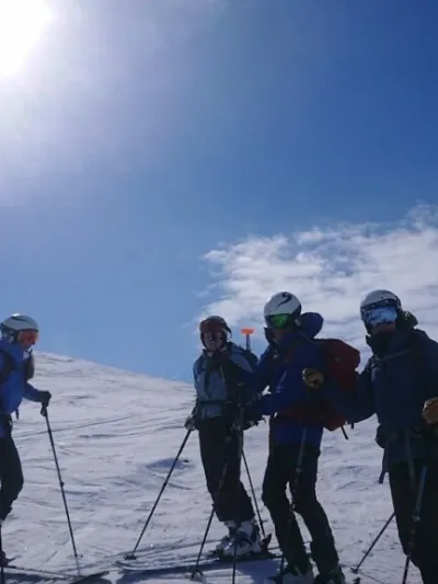 En gjeng med mennesker som er kommet på toppen og er klare til å kjøre nedover (vinter)