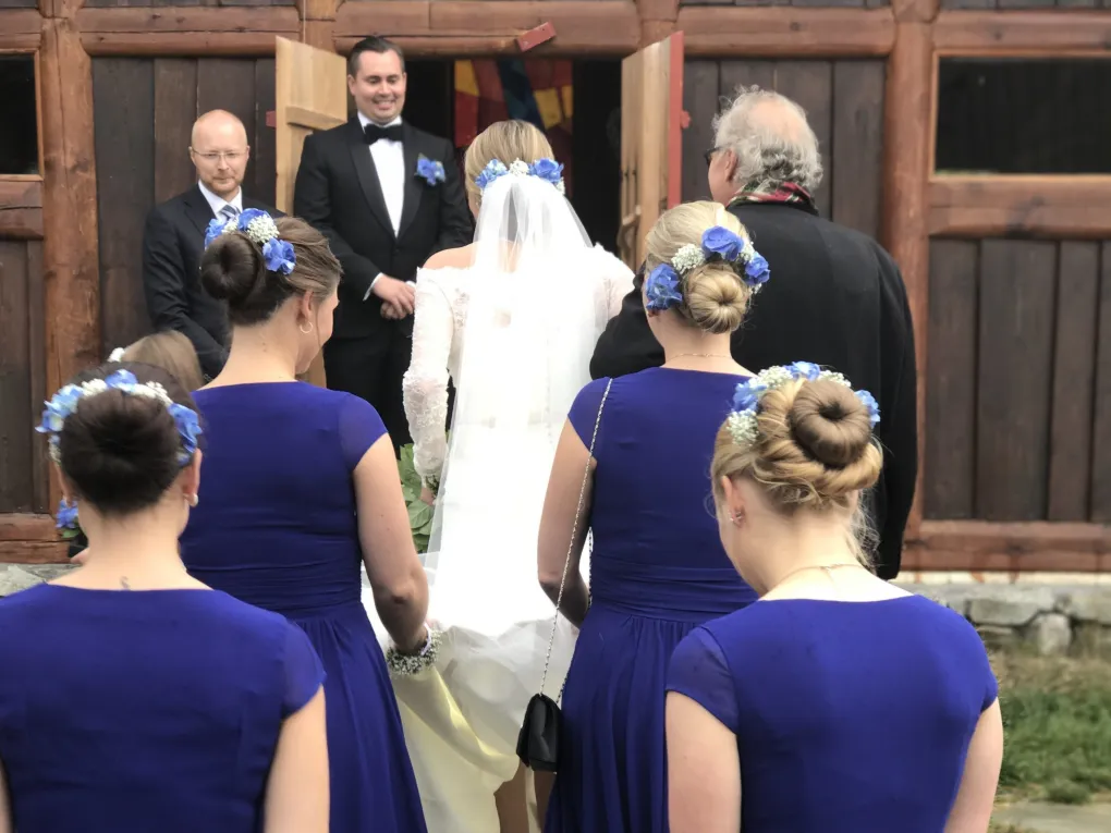 Her er det bilde av noen som skal gifte, og som går inn kirkedøra, brudepikene har på seg blåe kjoler.