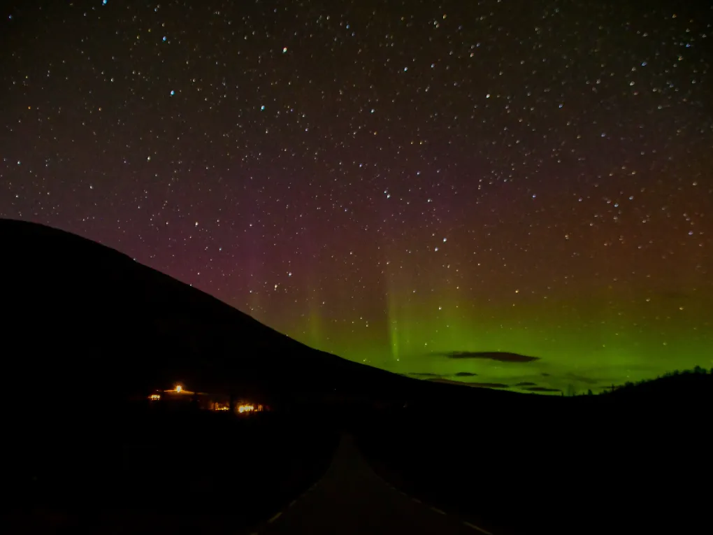 Bilde viser nordlyset stigende langs fjellhorisonten