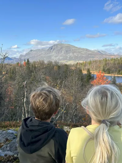 Gutt og jente sitter på fjell og ser utover Hemsedal