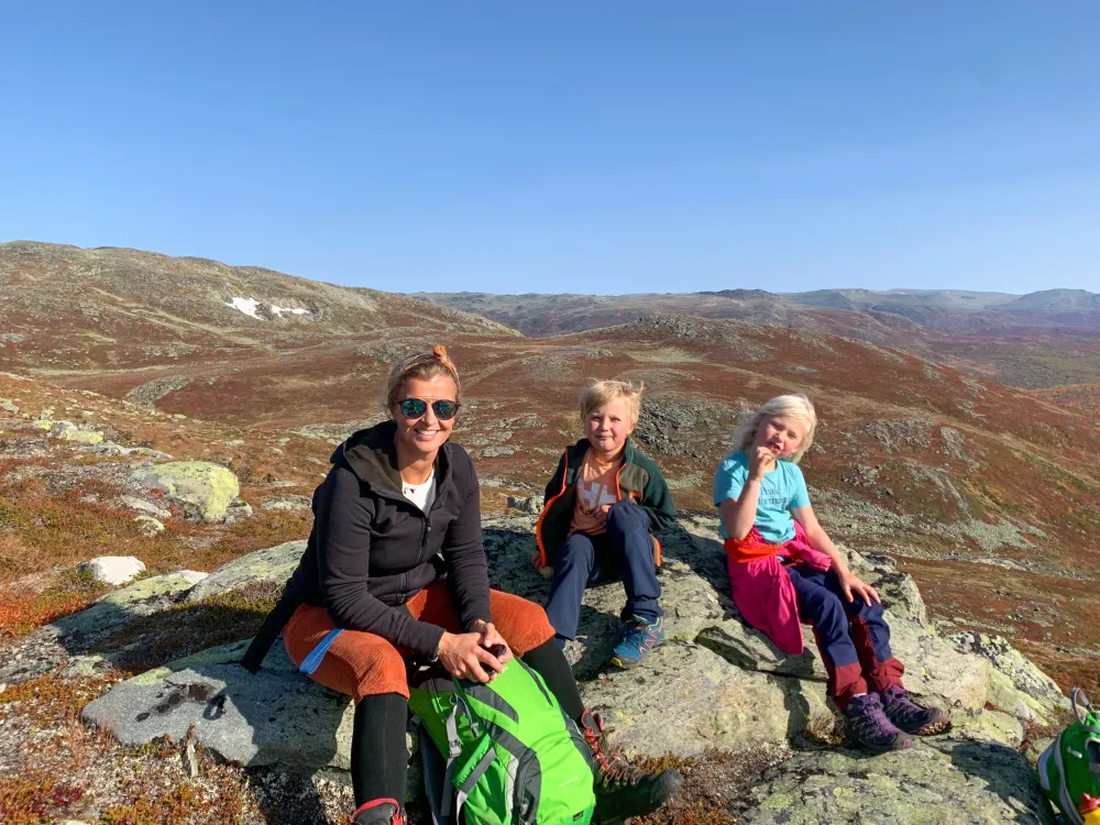 Kvinne med to barn sitter på fjellet i Hemsedal